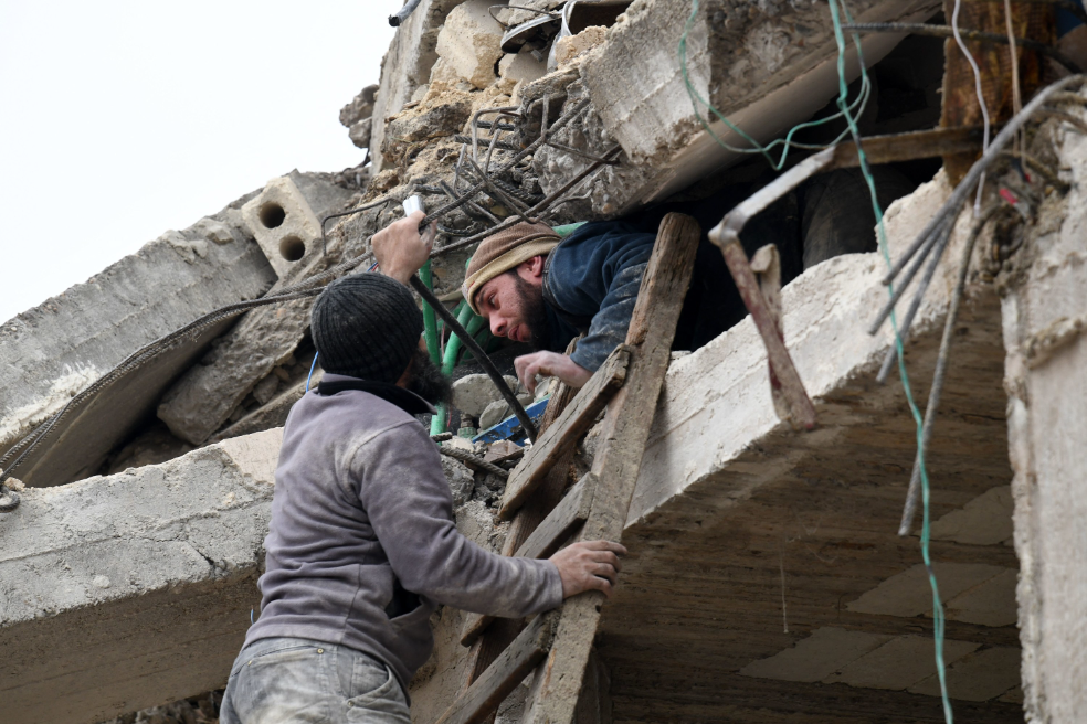 someone on a ladder reaching out to help an injured man crawling out from building rubble