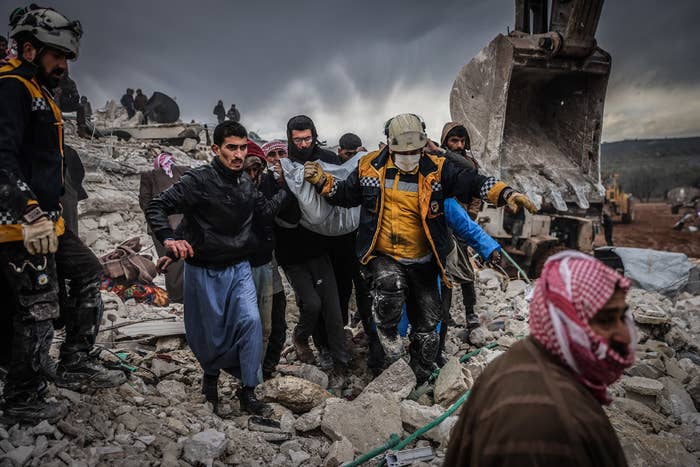 a group of people walk through earethquake rubble