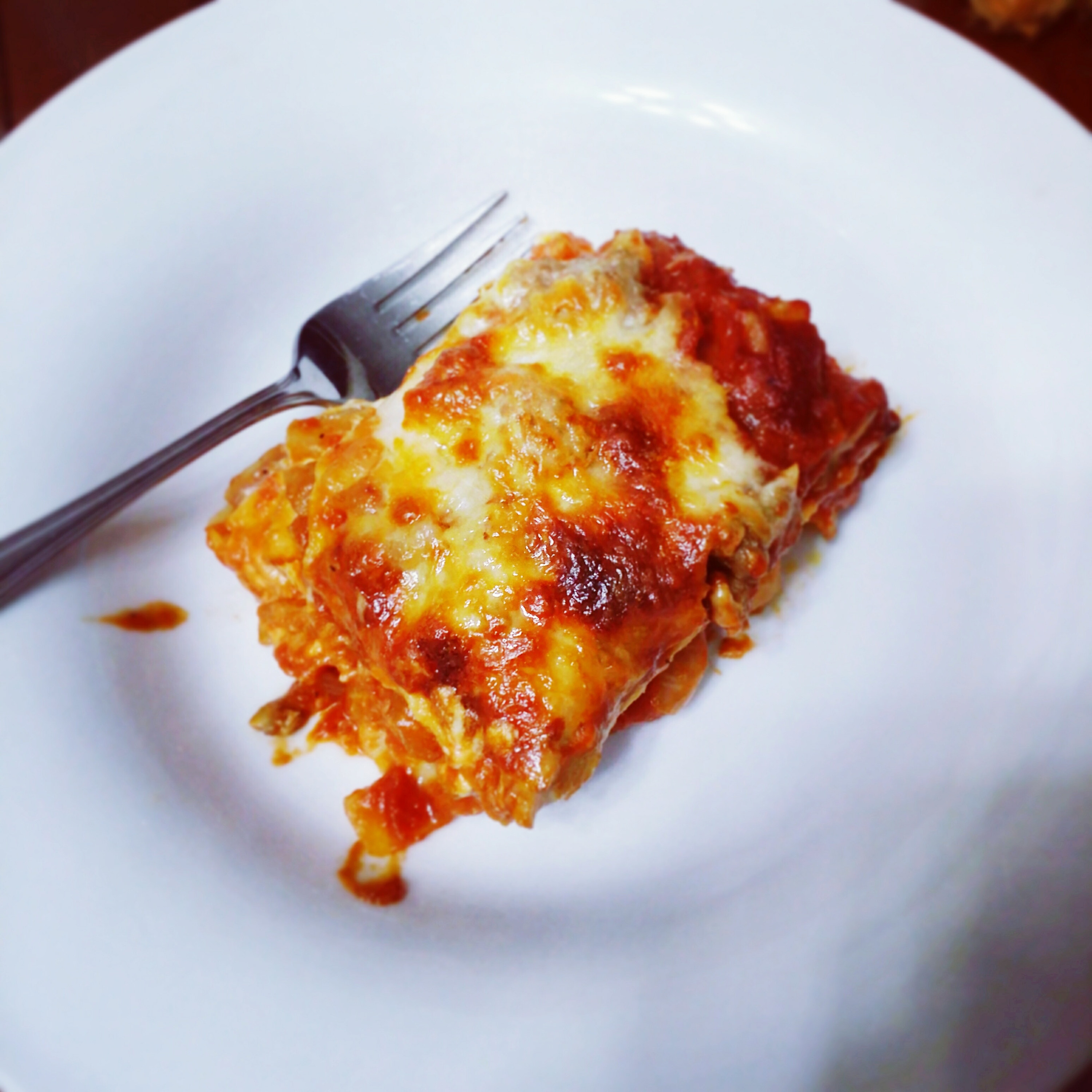 A crispy slice of lasagna on a plate.