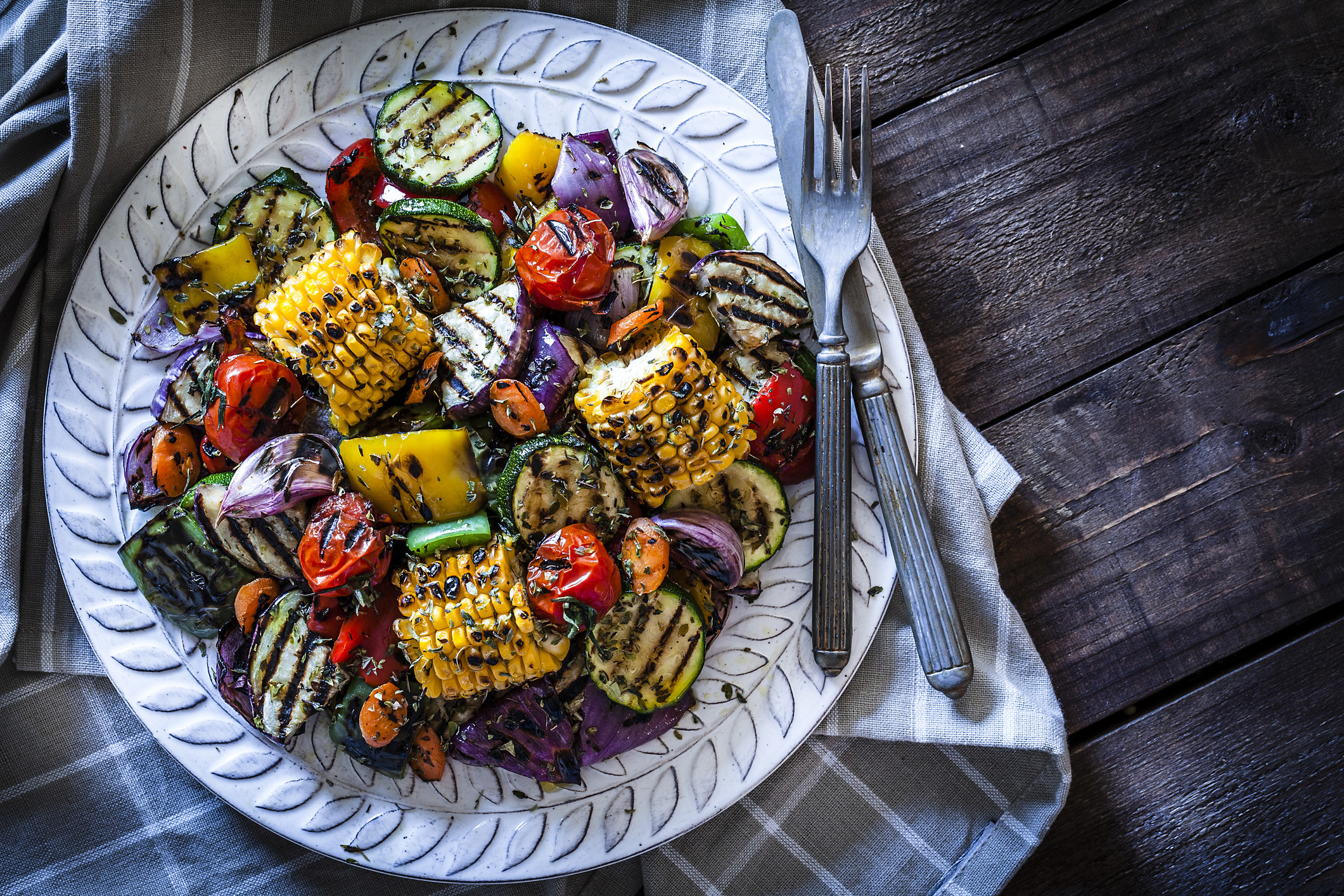 Grilled vegetables plate shot from above on rustic wooden table.