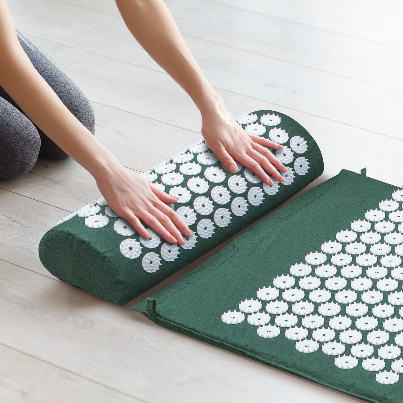 a person adjusting the acupressure pillow and mat