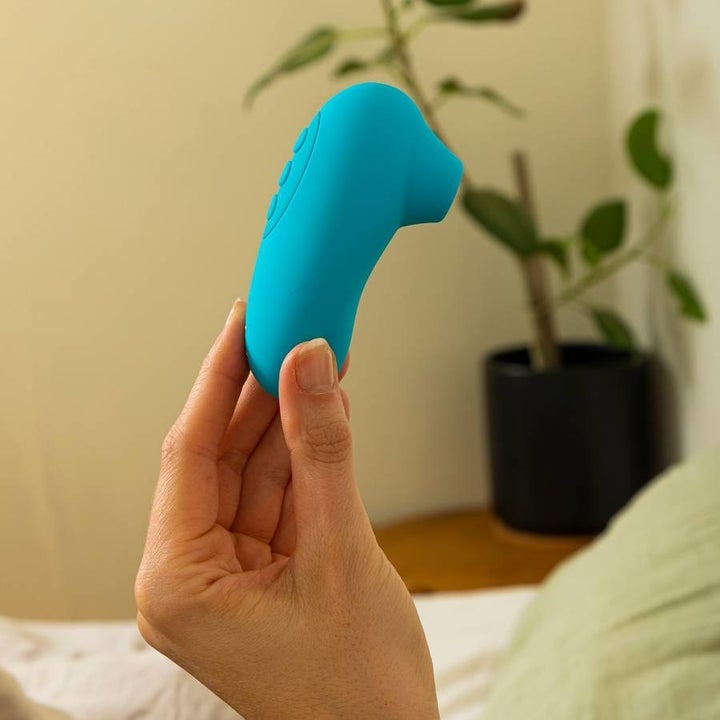 Hand holding blue suction vibrator