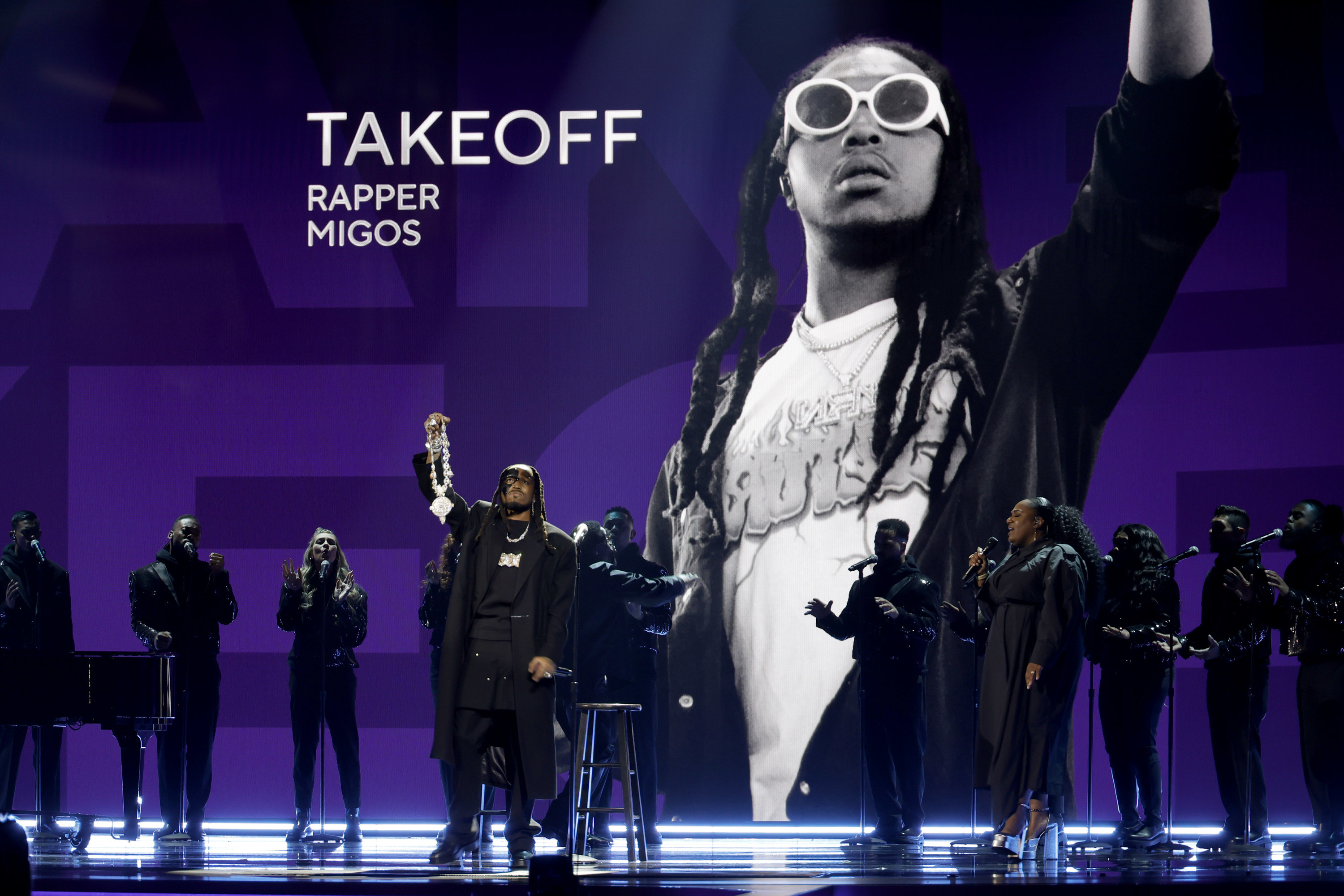 Quavo on stage at the Grammys holding up Takeoff&#x27;s chain