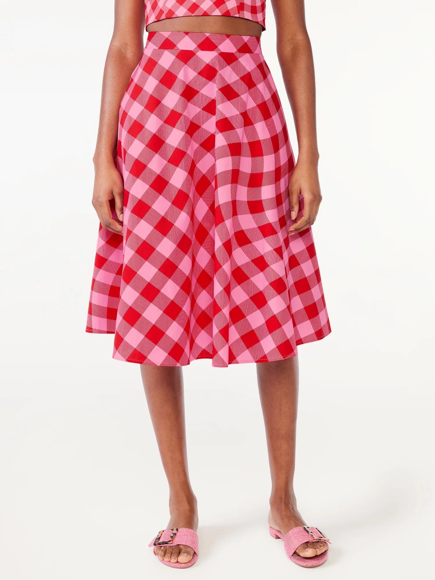 Model with a pink and red checkered skirt with matching top and pink shoes