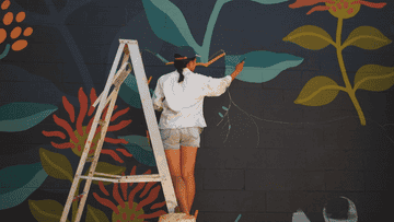 femme réalisant une peinture murale