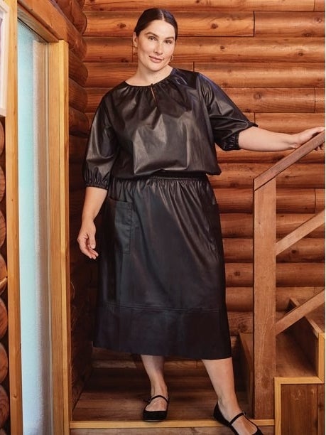 Model wearing black skirt and top and black shoes