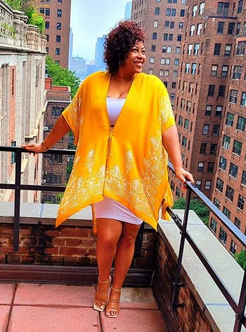 reviewer wearing yellow cover-up over a dress