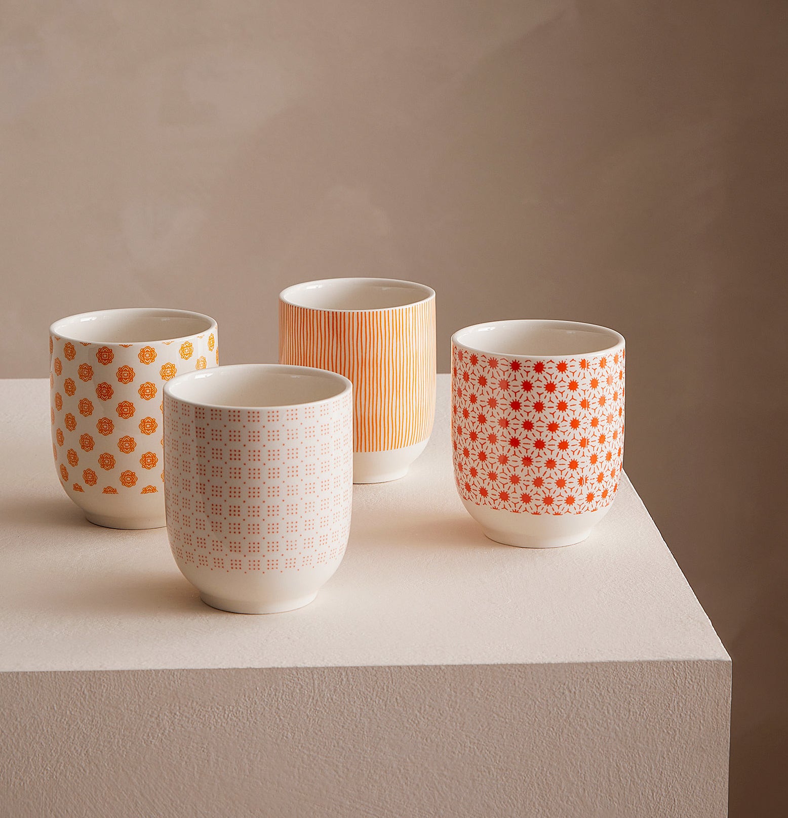 a set of four mugs with different designs on each