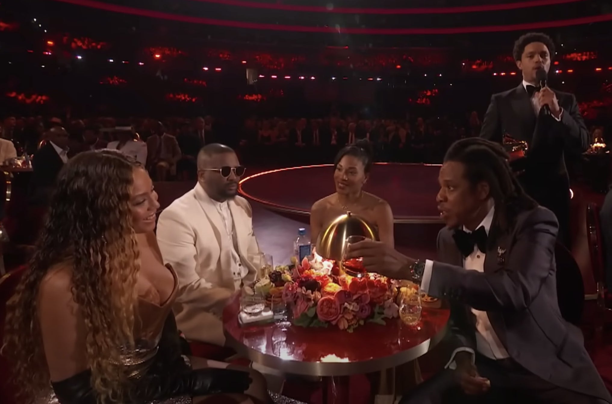 Jay tries to pass a small glass to Beyonce