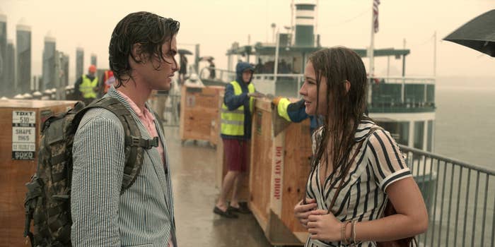 The two talking to one another in the rain as they stand by the docks