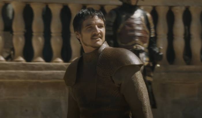 Oberyn smiles slightly as he stands in the middle of an outdoor arena