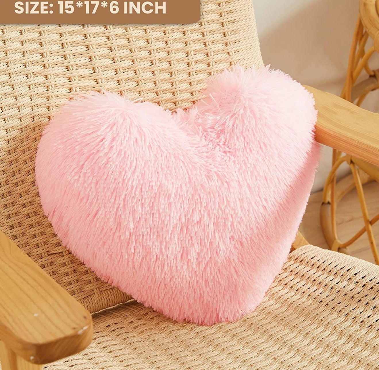 a fluffy heart-shaped pillow on a rattan chair