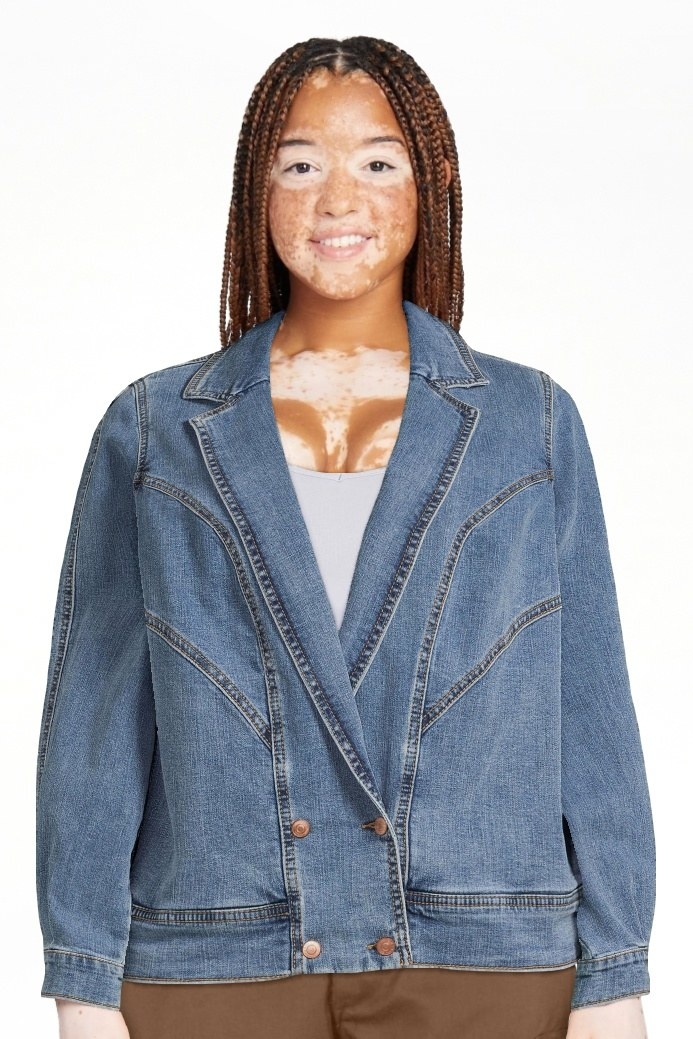 Model wearing denim jacket over white top and brown bottoms