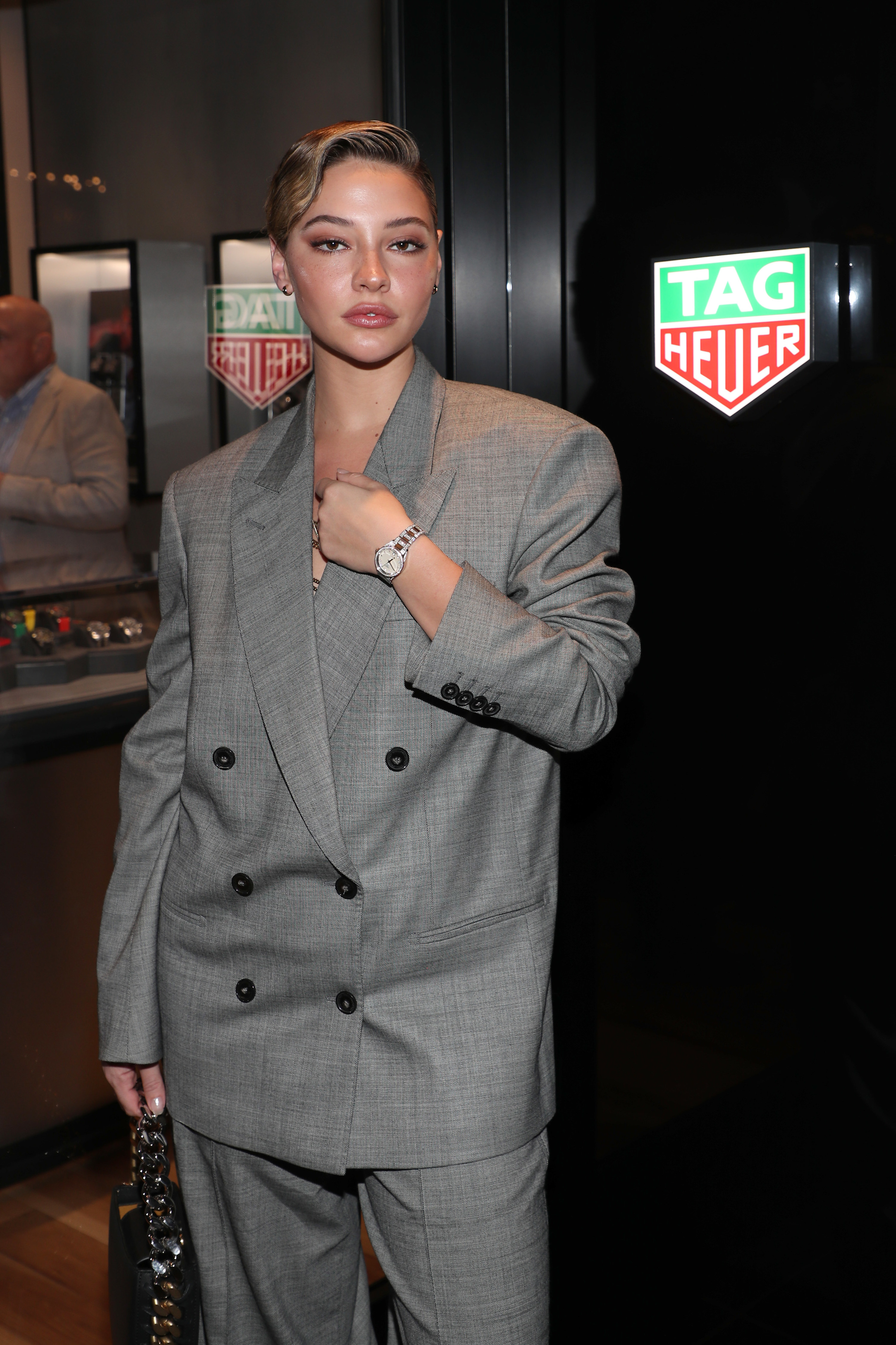 Madelyn wears a loose-fitting suit as she poses for a photo at an event