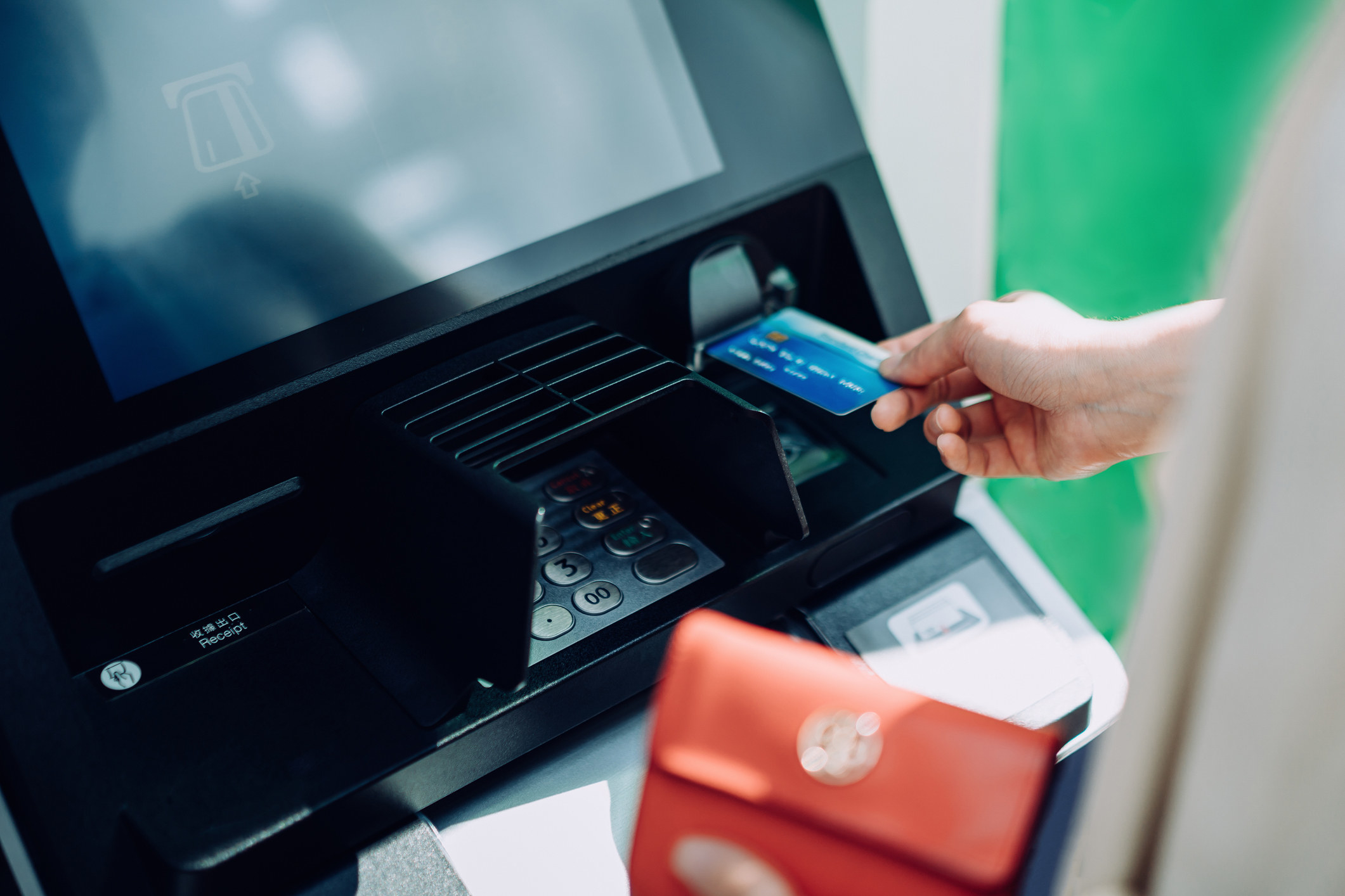 A person putting their card in an ATM machine