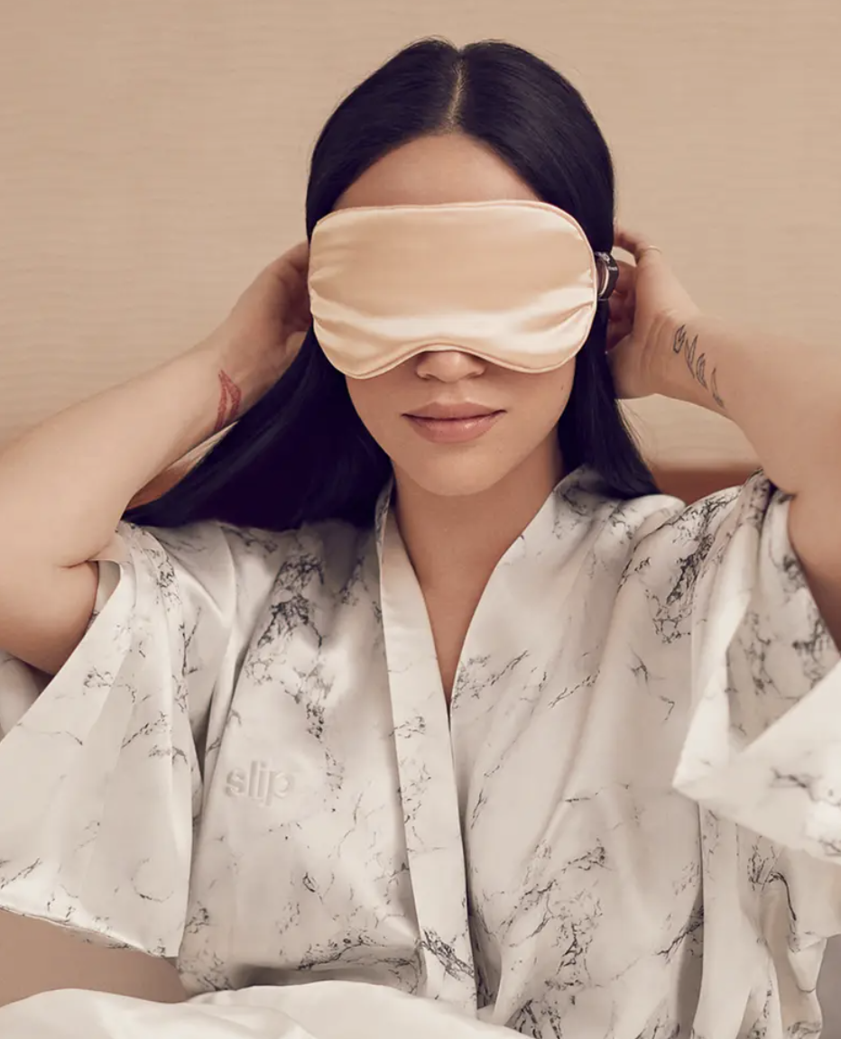 a person putting the silk eye mask on their face