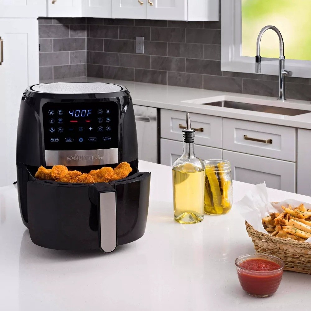 the black air fryer on a counter with fried food inside