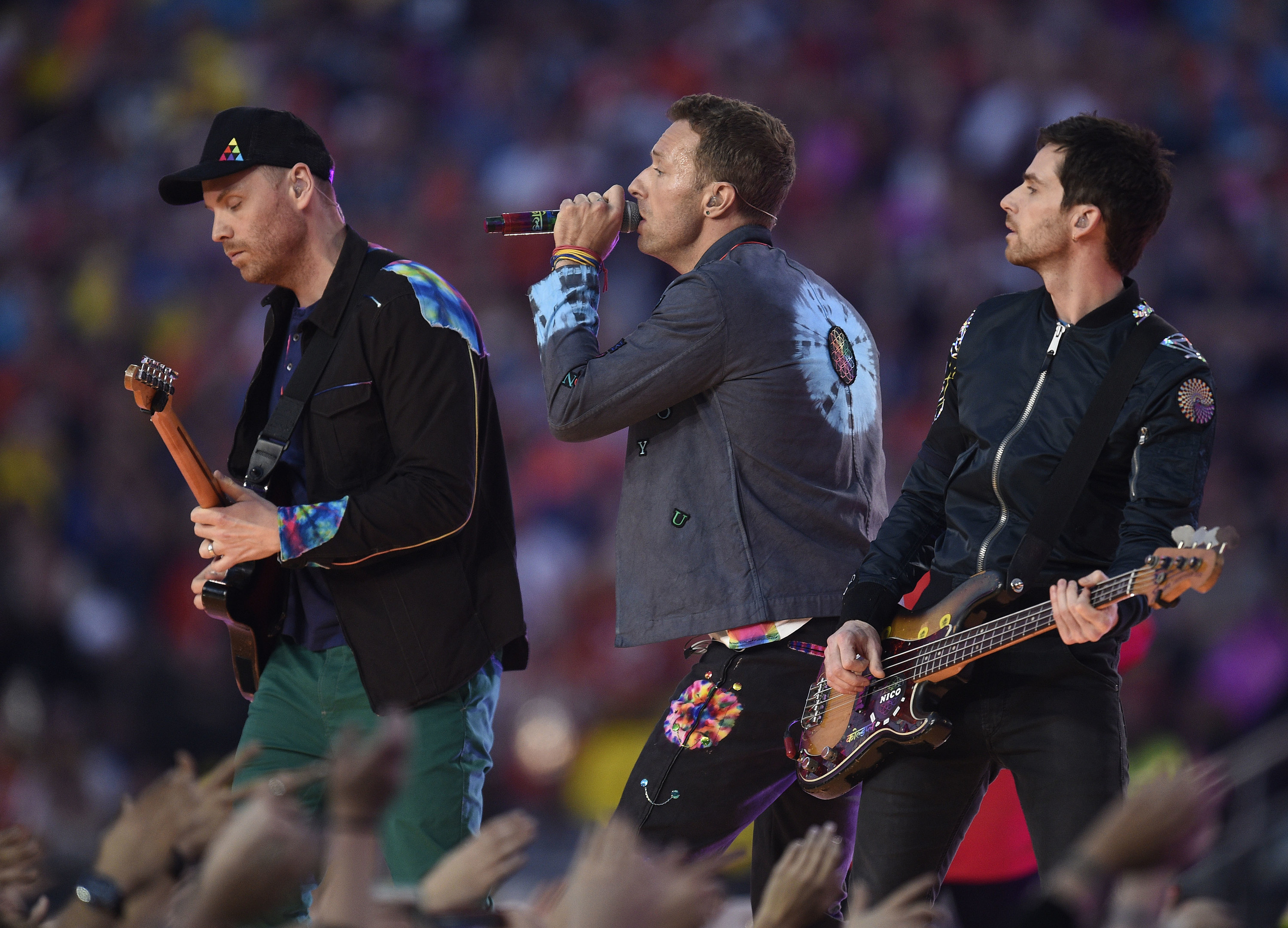 Chris Martin, center, performs with Coldplay during halftime of Super Bowl 50