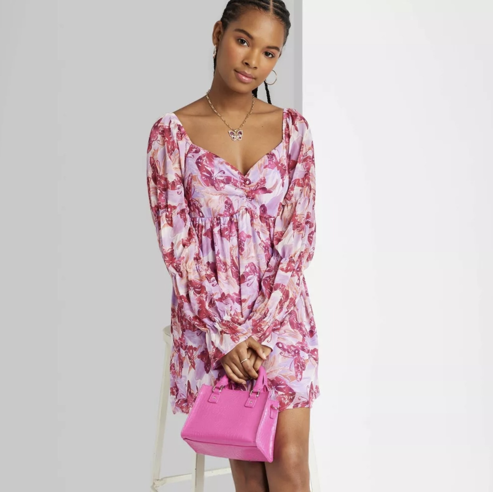 A model wearing the dress in a pink butterfly print