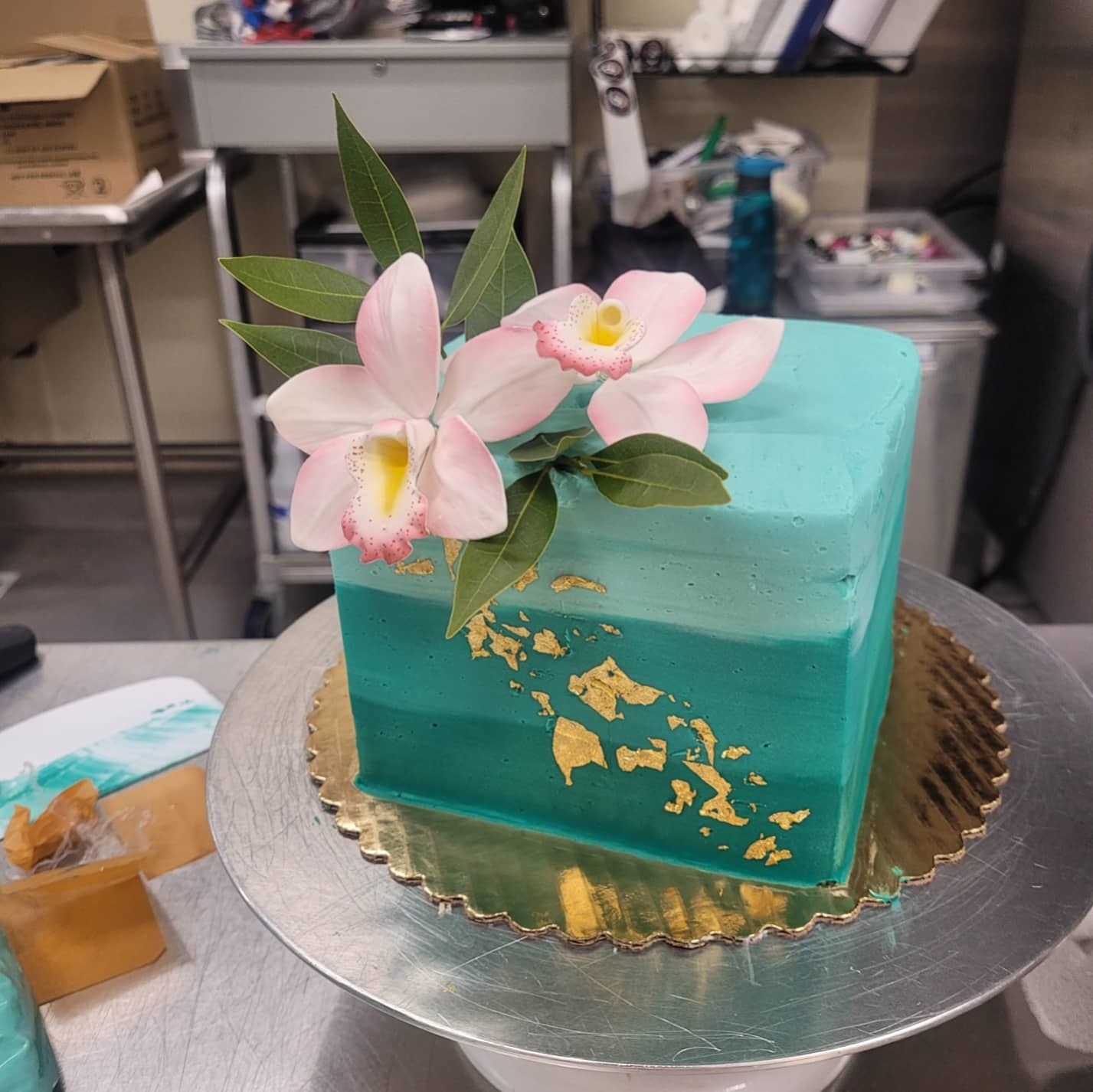 Reviewer image of an ombre cake decorated with gold leaf and flowers