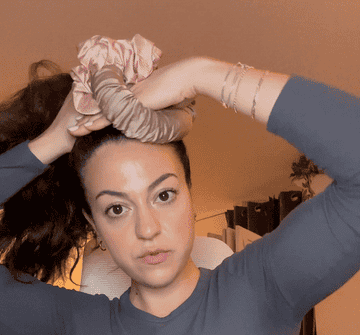 the author putting her hair into a ponytail