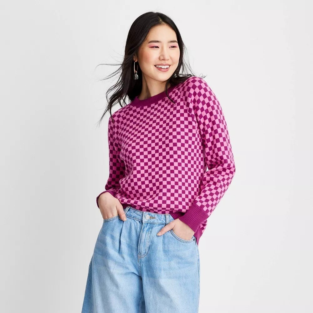 A model wearing the checkered sweatshirt with blue jeans