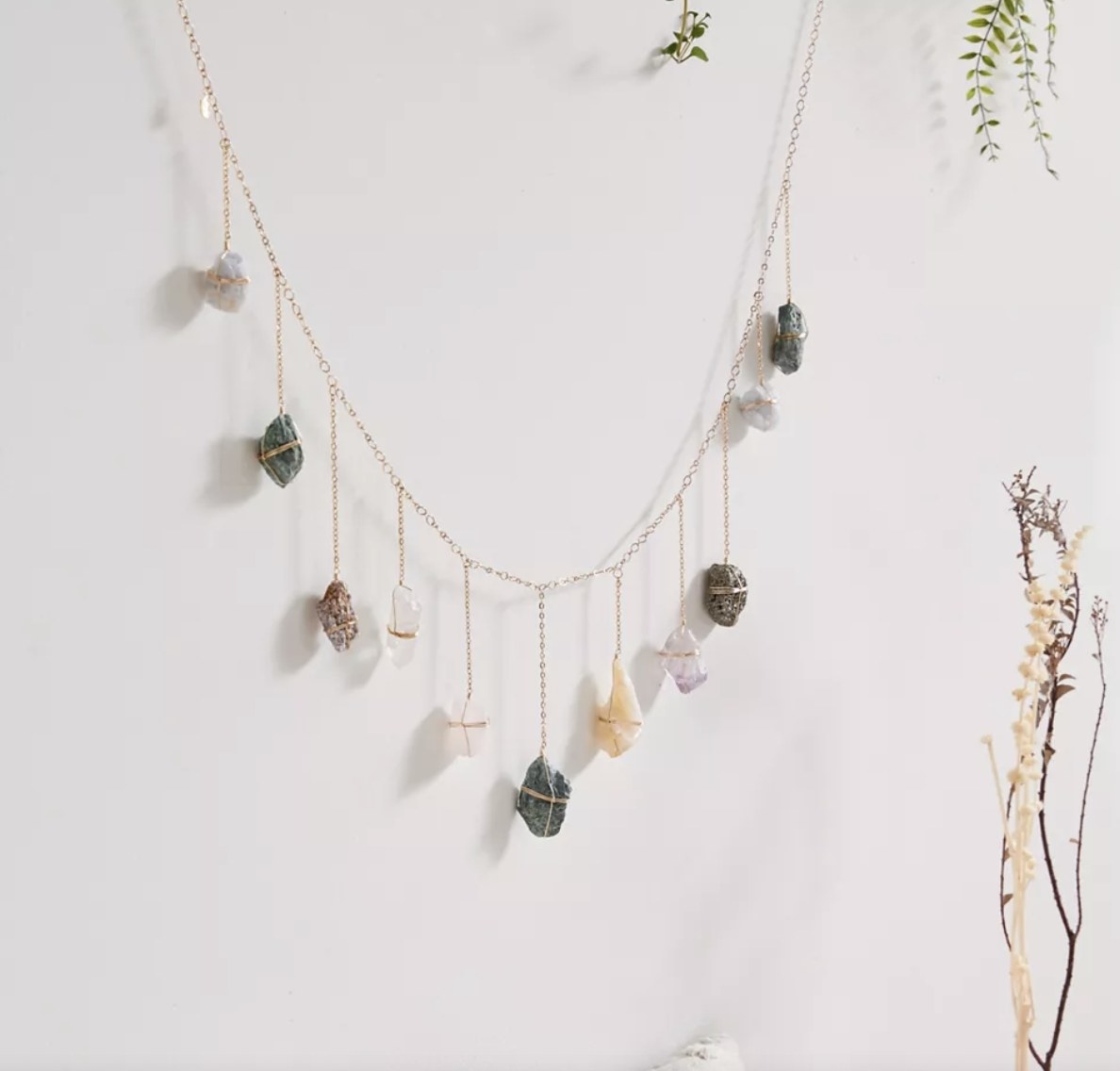 A garland of crystals hanging in front of a white wall