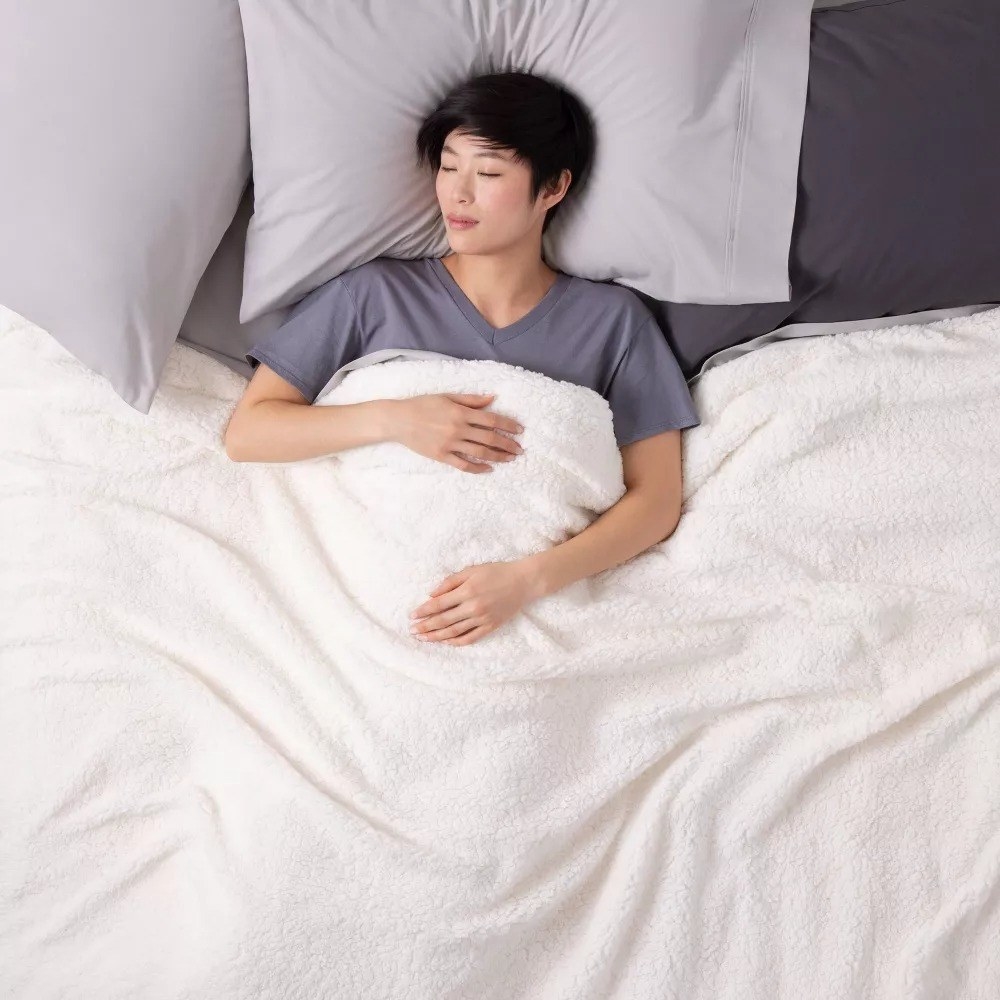 A model sleeping peacefully under the weighted blanket in white