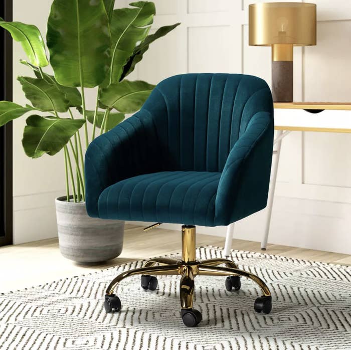 The dark teal chair on gold base and caster wheels