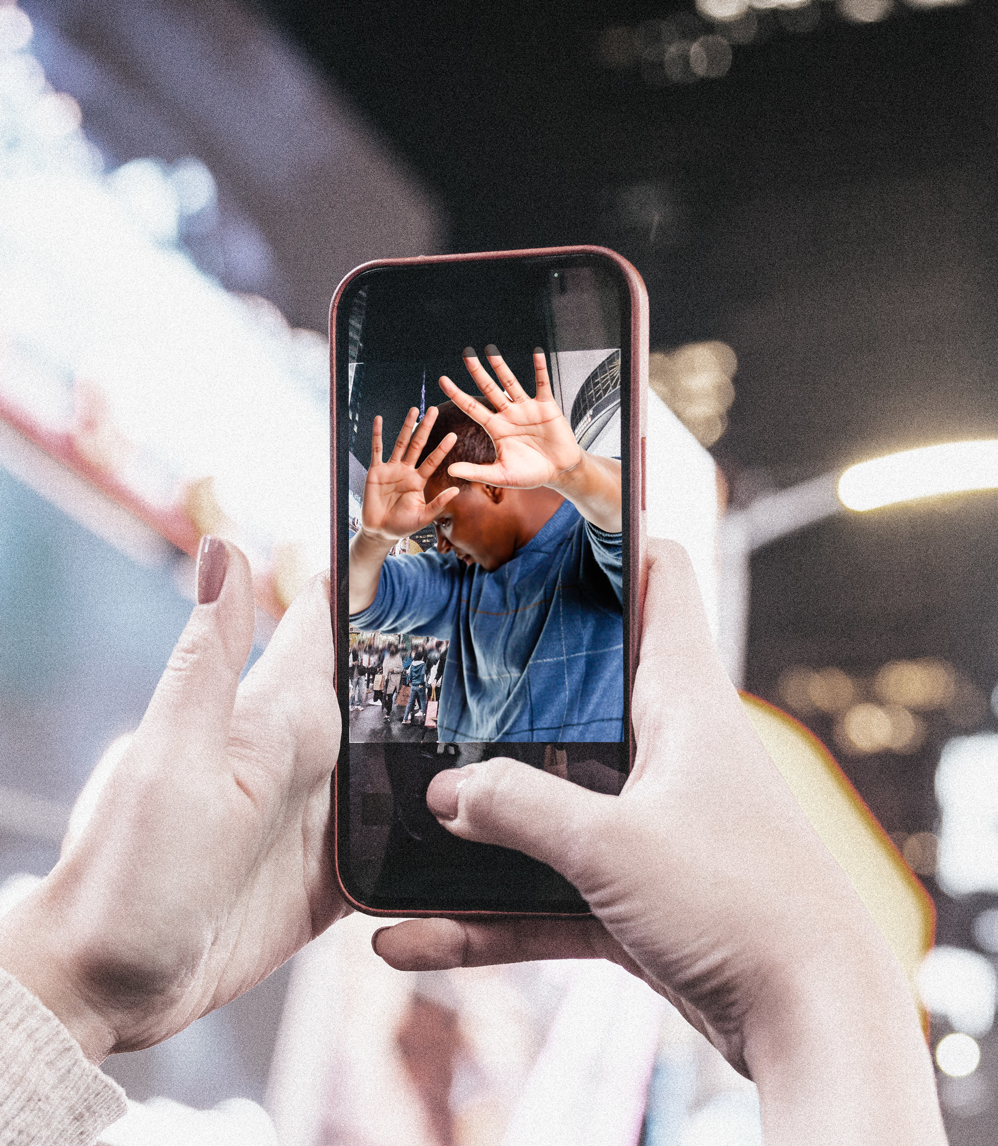 A phone screen&#x27;s camera shows a man shielding his face as someone tries to take a picture of him