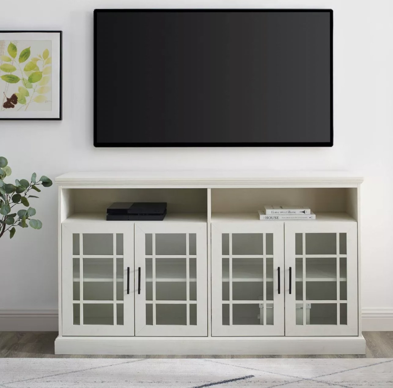 The white stand with TV mounted on wall