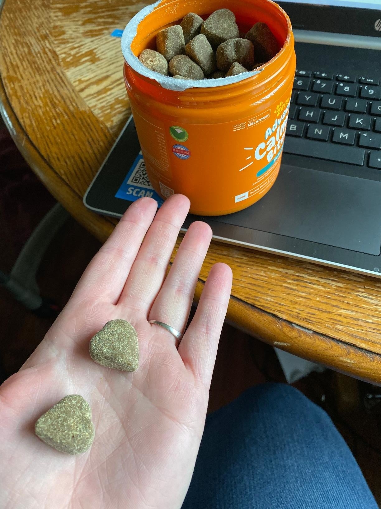 Reviewer holding 2  calming bites adjacent  to the calming bites jar