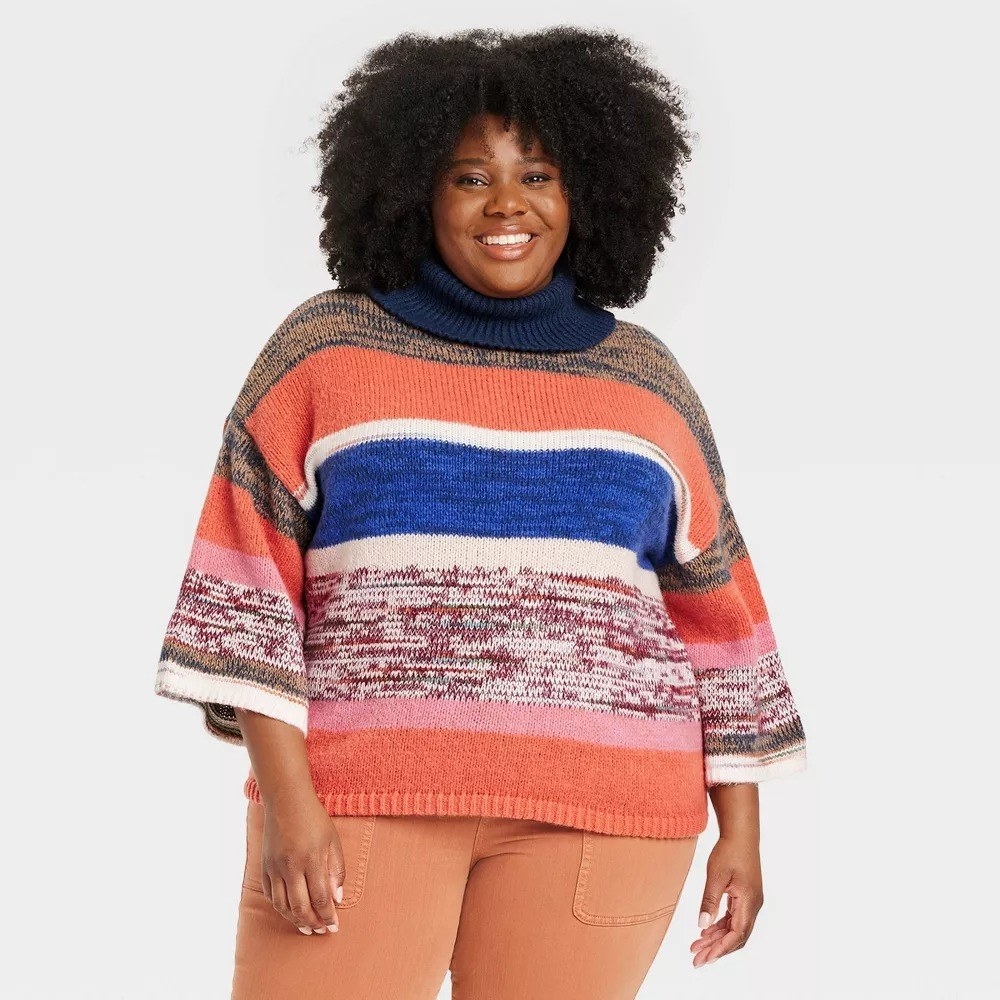 a model wearing the multicolored striped cowl neck sweater