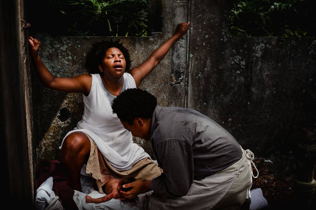 A Black doula assisting a Black mother giving birth