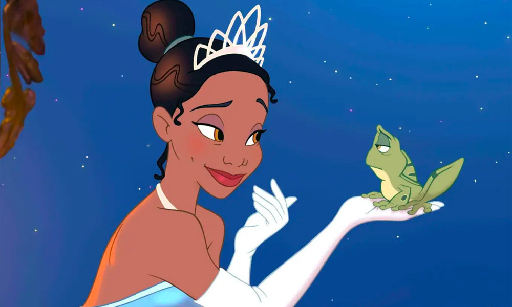 Princess Tiana holding a frog in the palm of her hand as she looks into its eyes