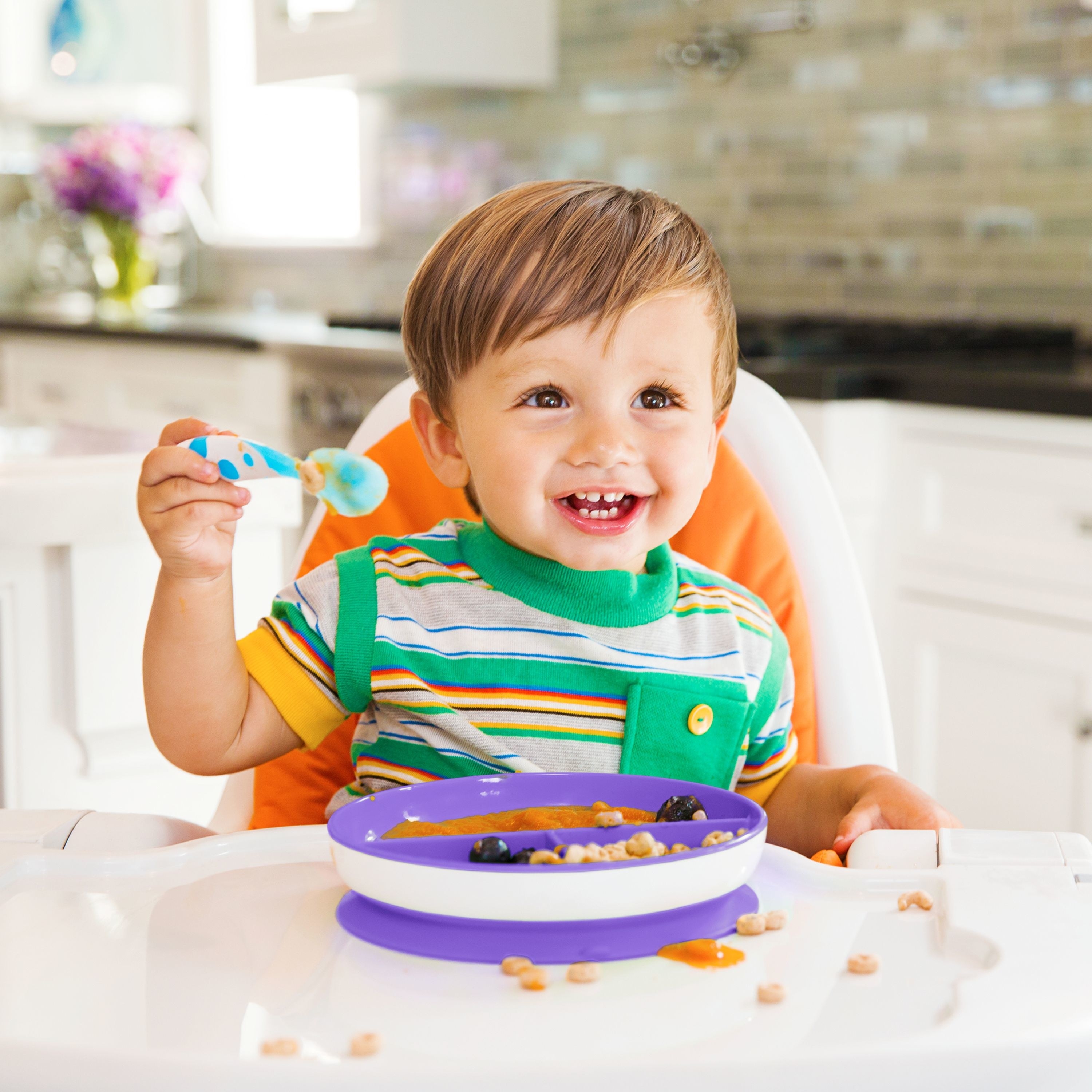 a child in a high chair eats from one of the suction plates