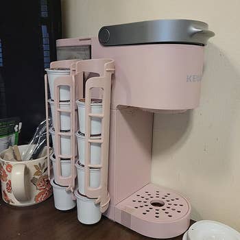 a reviewer's pink coffee maker with the pink dispensers attached to the side