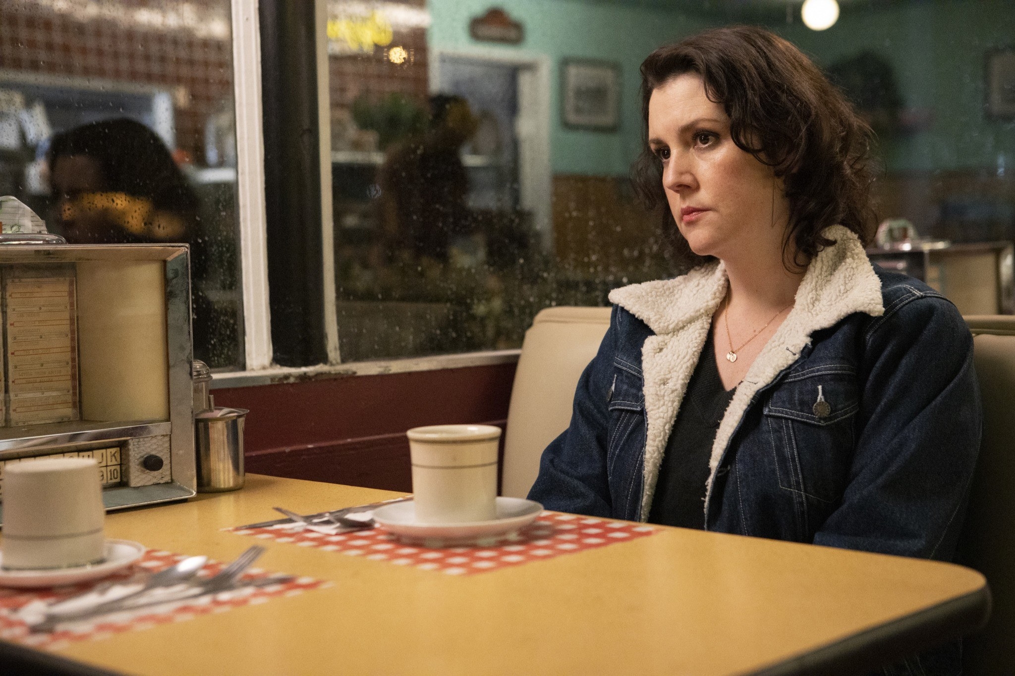 Melanie sitting at a diner table