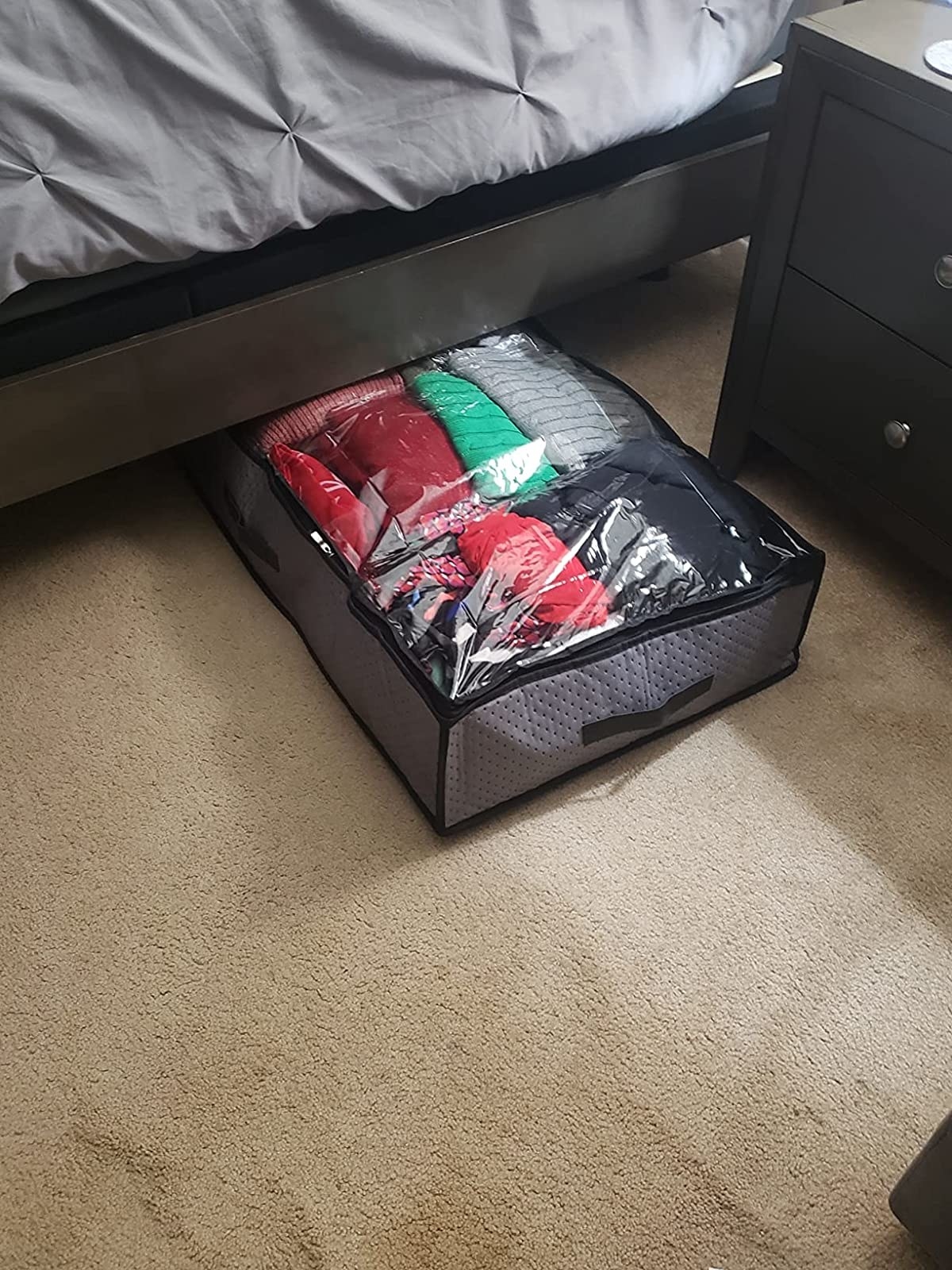 The grey storage bag being slipped under a reviewer&#x27;s bed