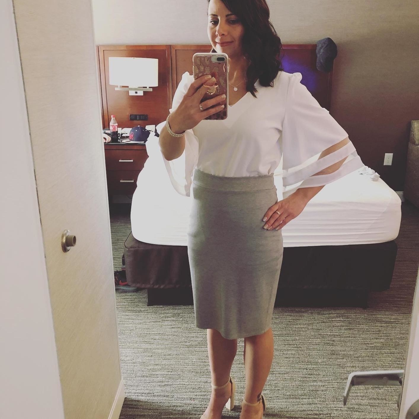 Reviewer wearing the white top with a gray pencil skirt