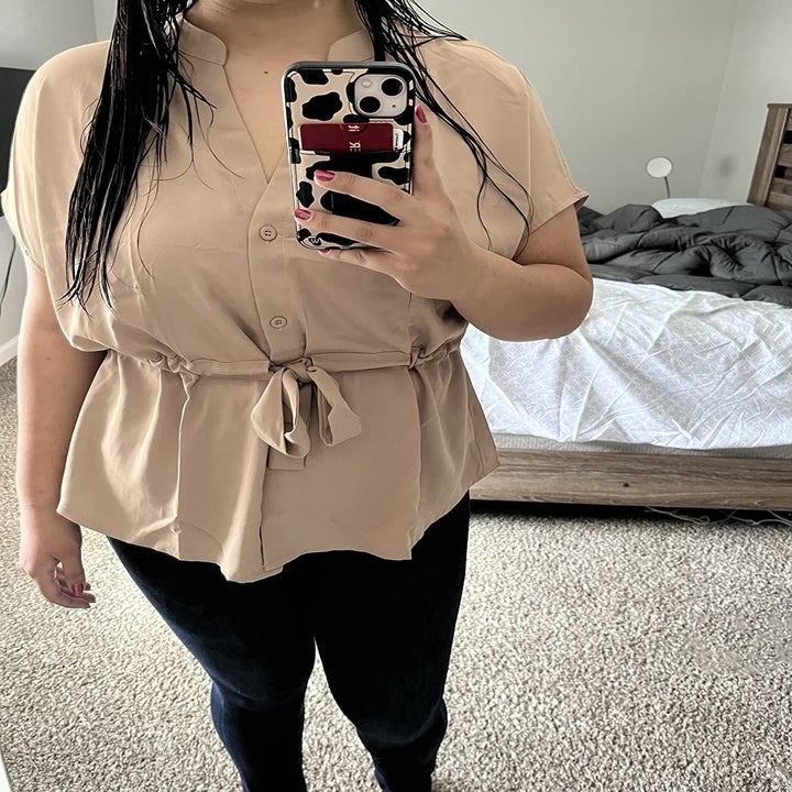 Reviewer wearing the top in a light beige color
