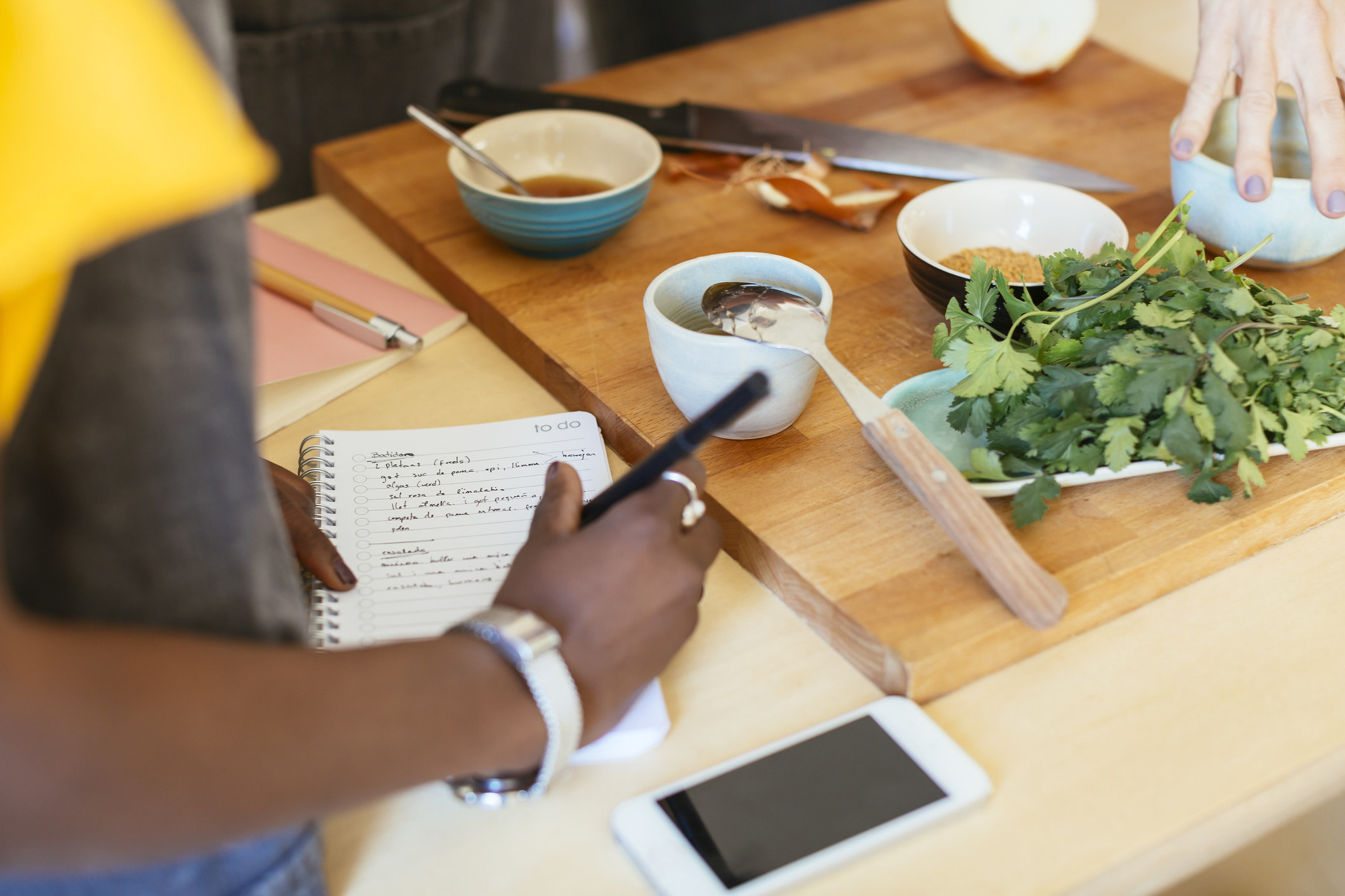Close-up of woman taking notes while cooking.