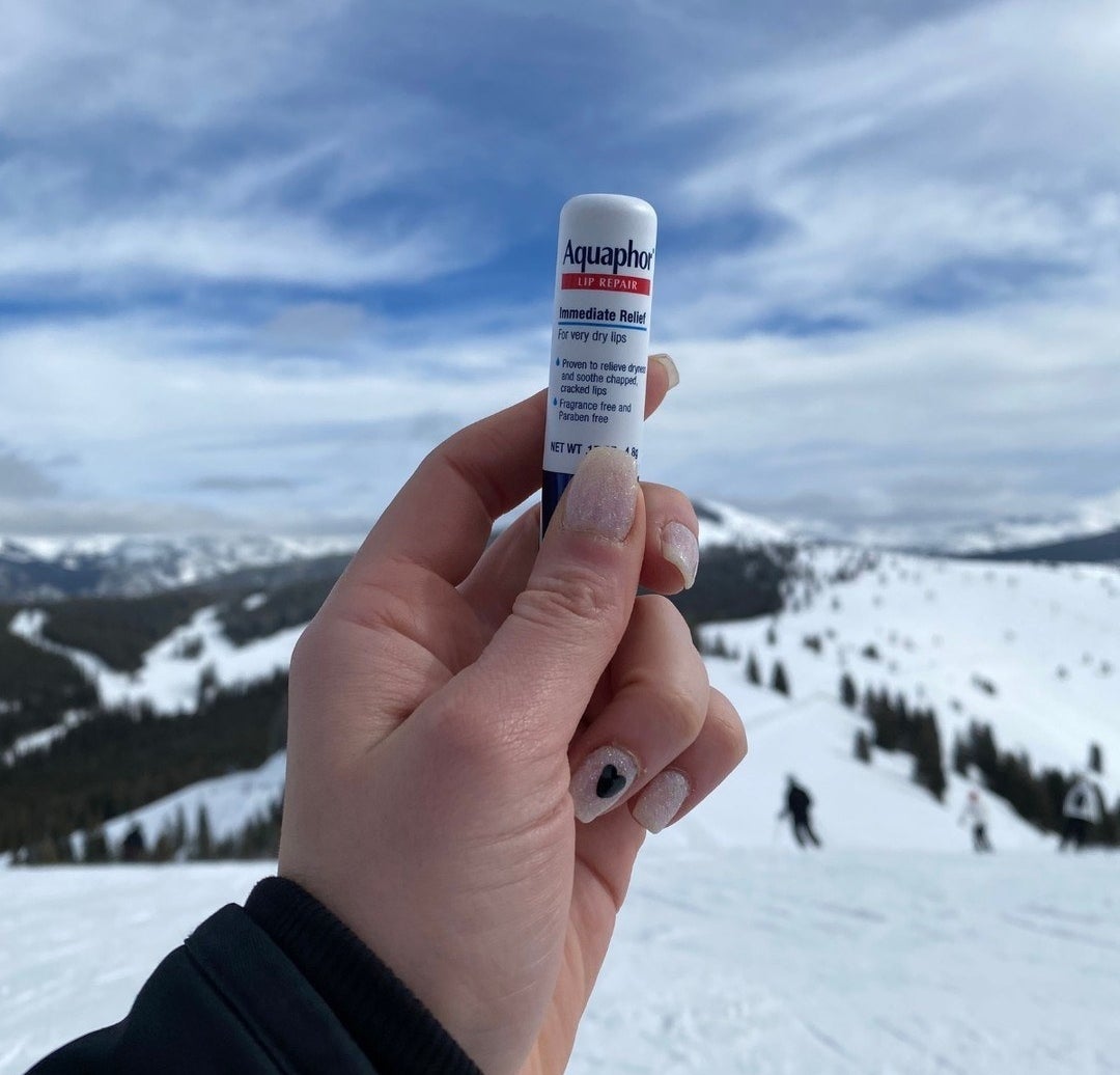 someone holding the lip balm on a ski mountain