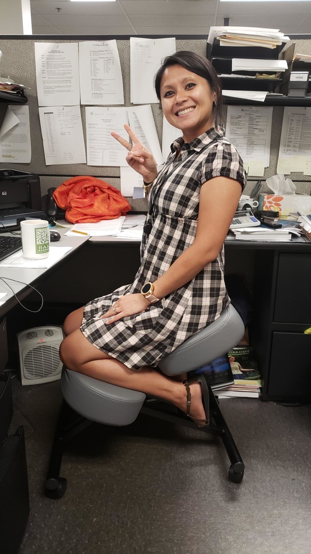 reviewer posing while kneeling on ergonomic chair