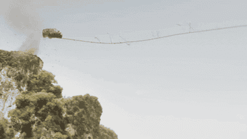 A car uses a rope bridge to swing across a gap