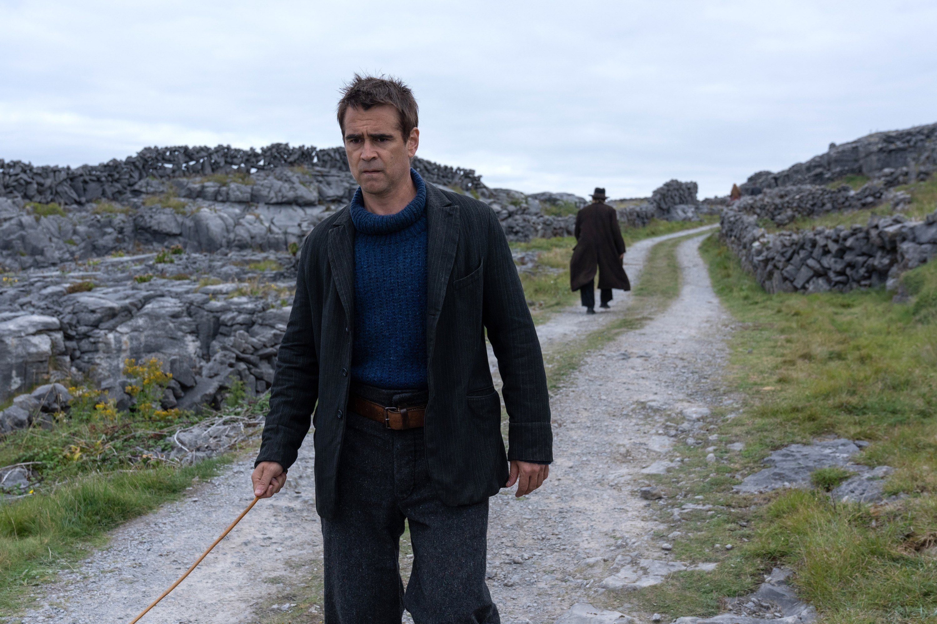 Colin Farrell walks down a road