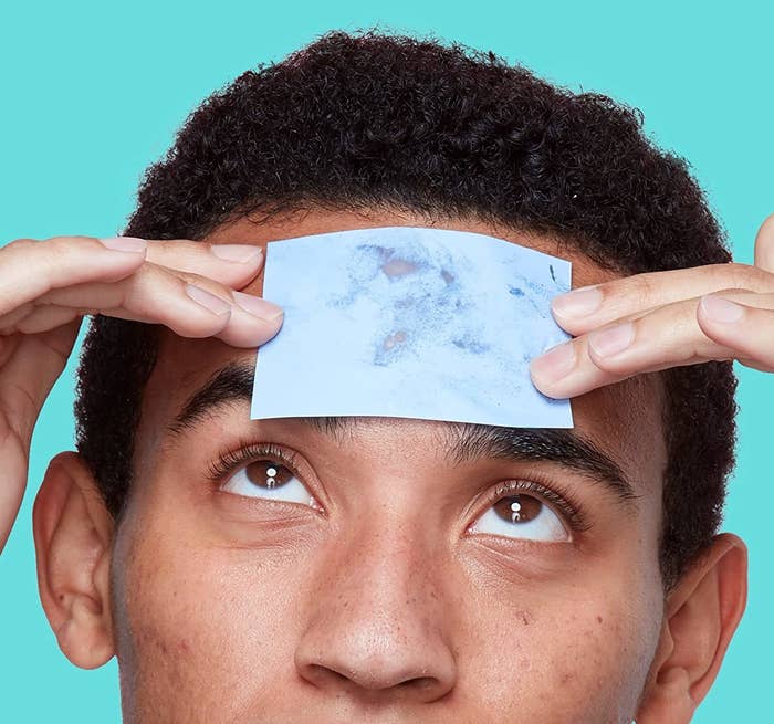 a person using a blotting paper to bot their forehead