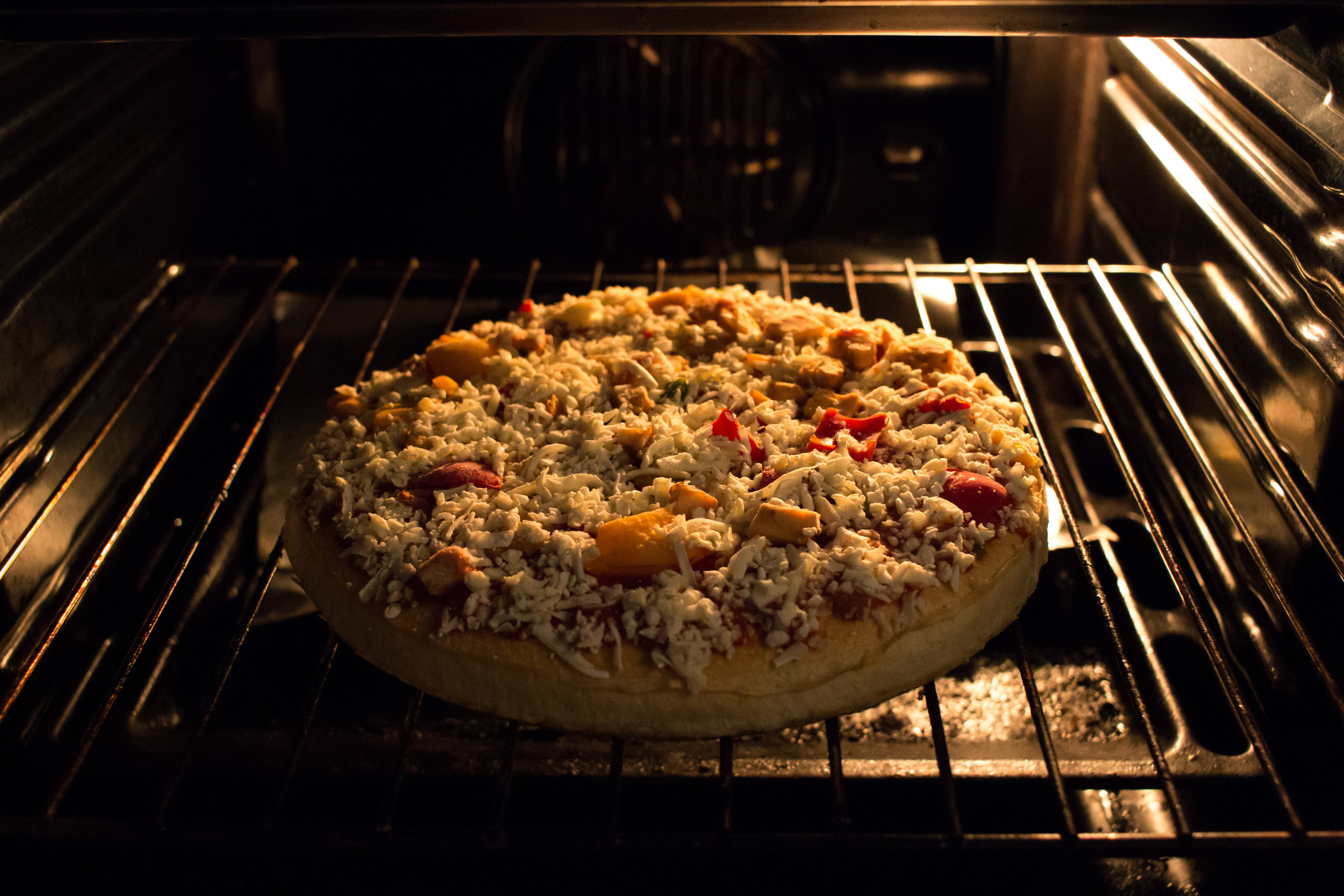 A frozen pizza in an oven.