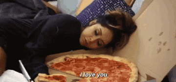 Snooki lays beside a box of pepperoni pizza. She holds a slice of pizza and says, &quot;I love you.&quot;