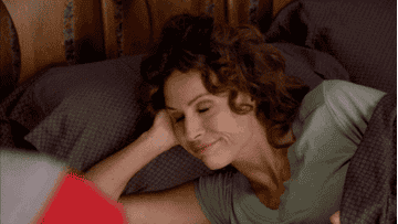 woman with curly hair lies in bed